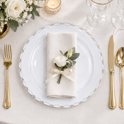 Elegant white and gold wedding table setting with floral napkin decor