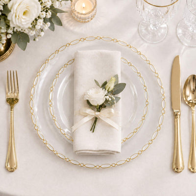 Elegant gold table setting with floral napkin and clear glass charger plate