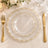 Elegant gold chain glass charger plate with gold flatware on a white table setting