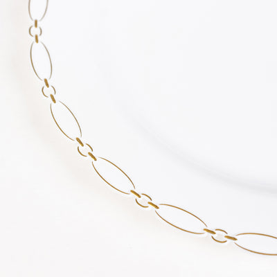 Minimal gold chain necklace on white background, elegant jewelry detail