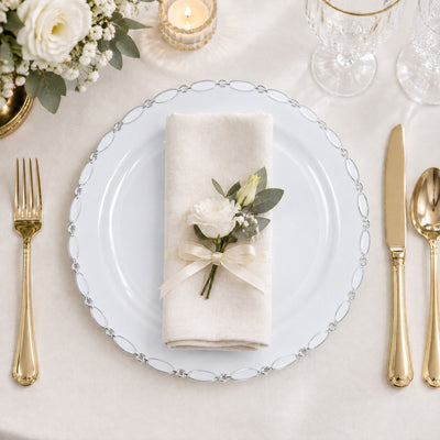 Elegant white and gold wedding table setting with floral napkin and crystal glassware