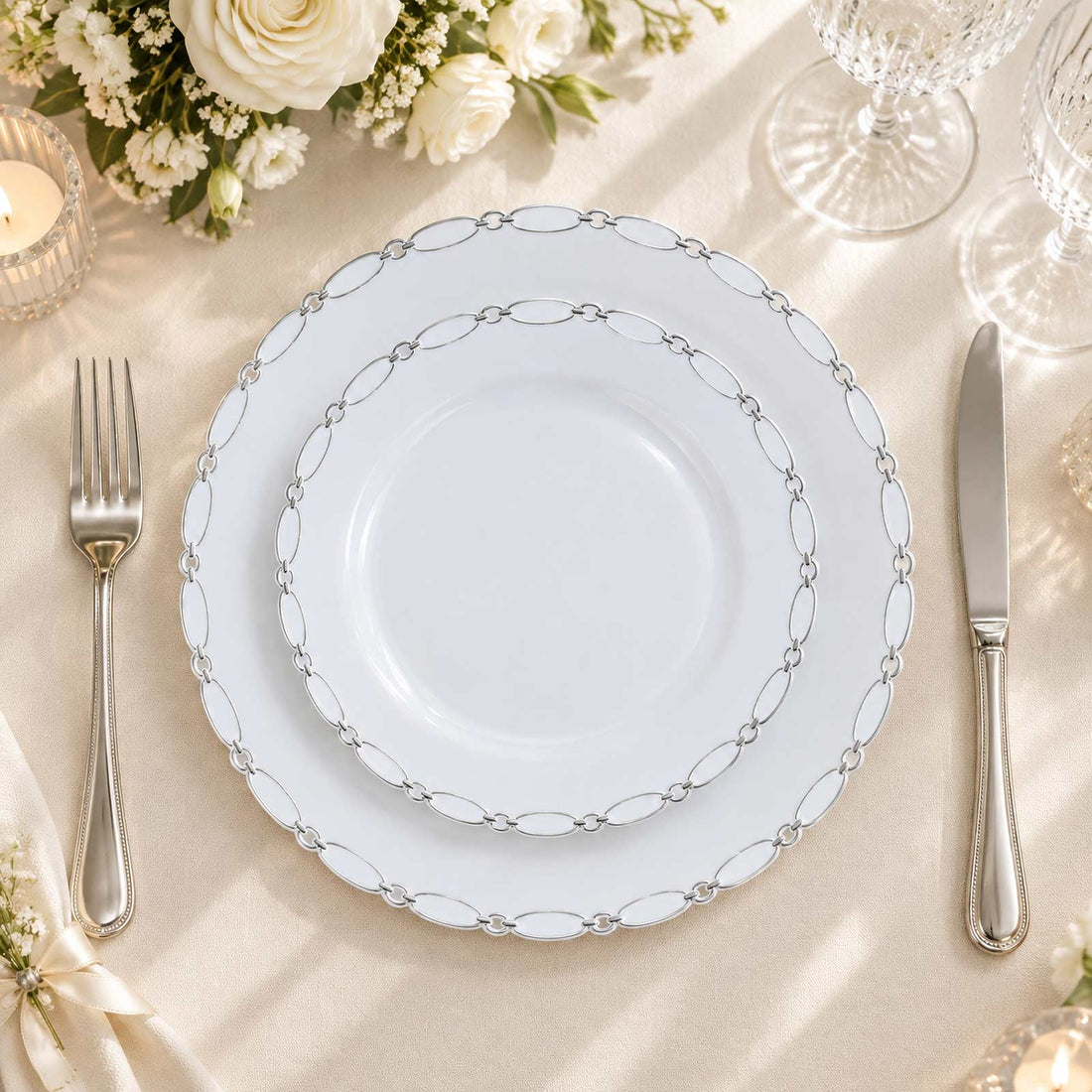 Elegant white wedding dinner plate with silver chain border on a formal table setting