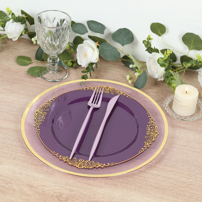 Elegant purple plate set with gold accents, fork, and knife on a stylish table setting.
