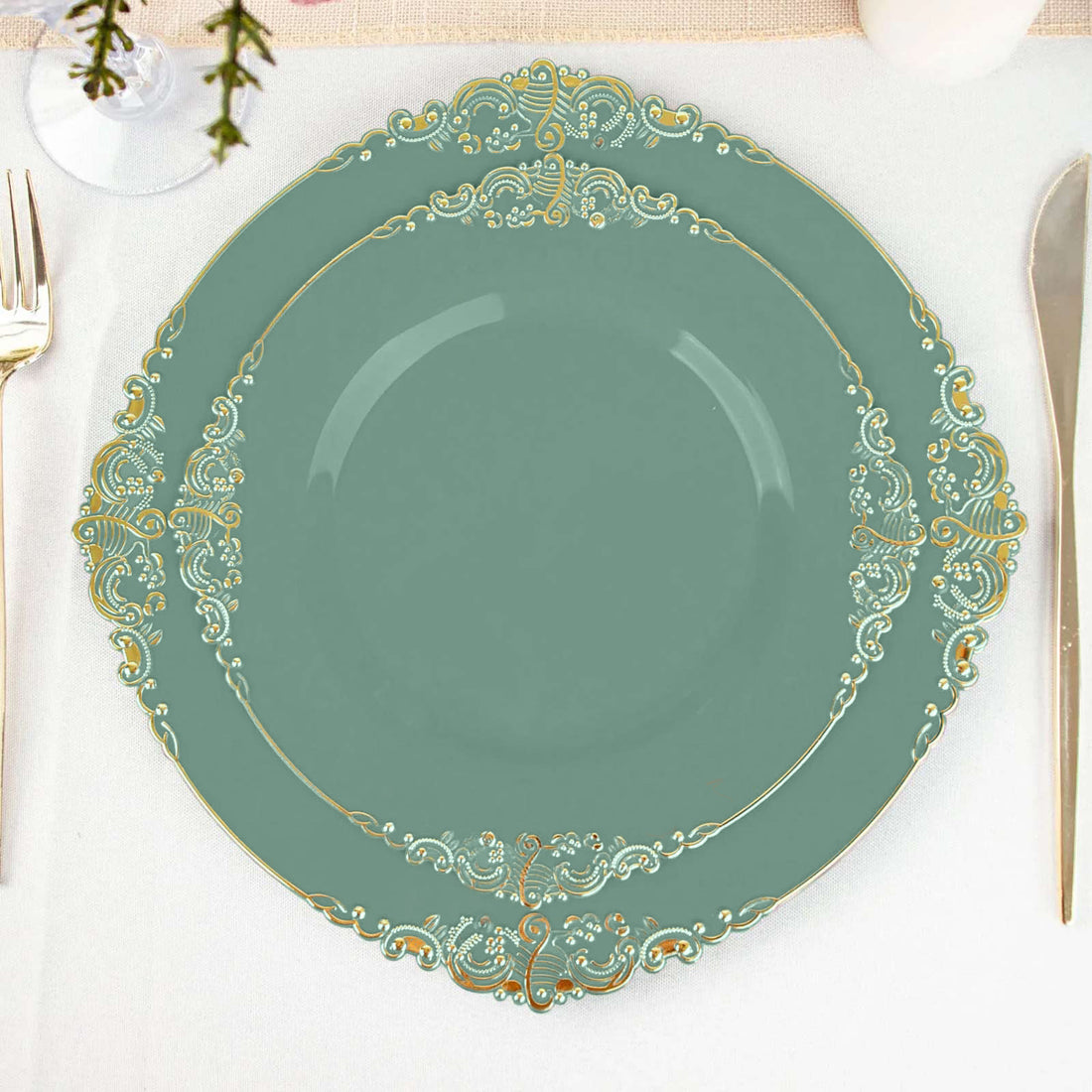 Elegant teal dinner plate with gold accents on a white table setting.