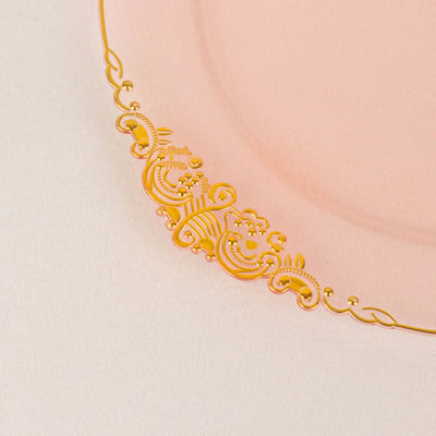 Gold ornate edge on a pink plate, showcasing elegant design details.