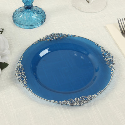 Blue decorative plate with intricate silver detailing on a table setting.