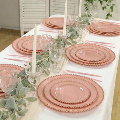 Elegant pink dinnerware set with gold detailing on a beautifully arranged table.