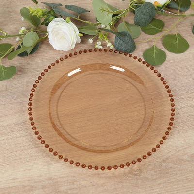Amber glass plate with beaded rim on a wooden surface.