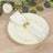 Elegant white napkin with gold ring on decorative plate.