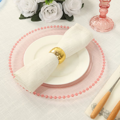 Elegant table setting with pink charger plate and white napkin.