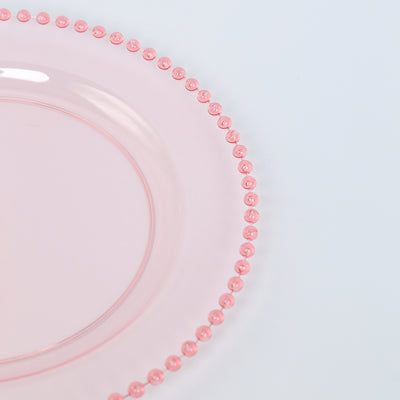 Pink glass plate with beaded rim detail.