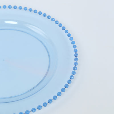 Blue decorative plate with bead trim on a plain background