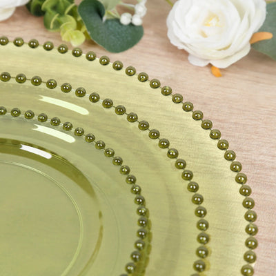 Green decorative plate with beaded edges on a textured surface.