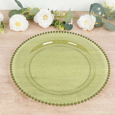 Green glass plate with beaded rim on a wooden surface.
