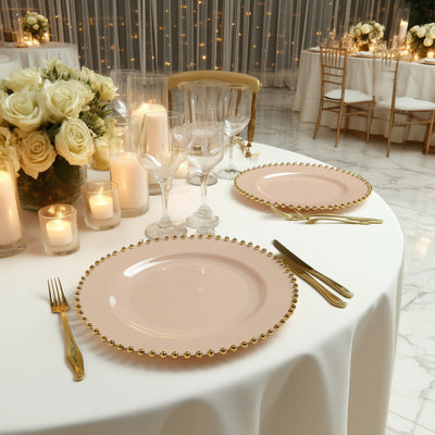 Elegant pink dinner plates with gold bead trim on a beautifully set table.