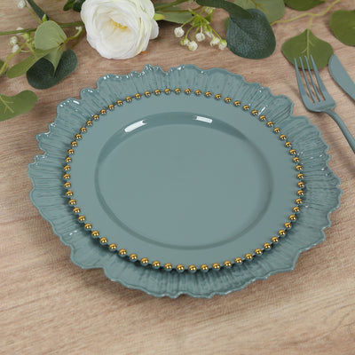 Blue decorative plate with gold beading on a wooden table setting.