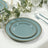 Elegant teal plates with gold bead accents, stacked on a table setting.