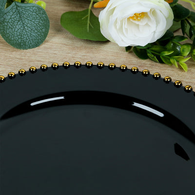 Black decorative plate with gold beaded rim on a wooden surface.