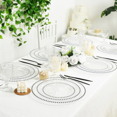 Elegant table setting with clear plates and floral decor. Perfect for events.