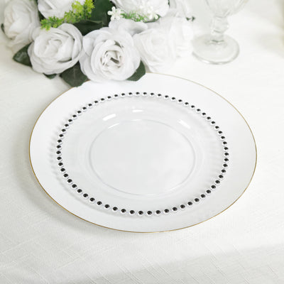 Elegant white plate with black beading and gold rim on a table setting.