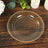 Elegant glass plate with gold glitter accents on wooden table.