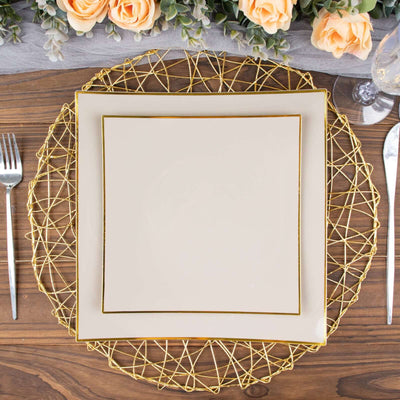 Elegant gold wire charger plate with a cream square plate on a wooden table setting.