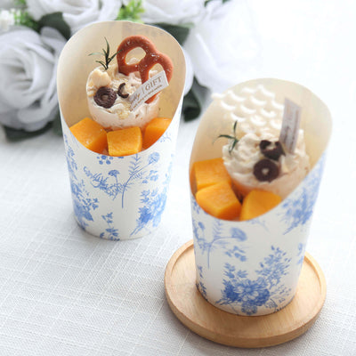 Dessert cups with fruits and whipped cream, styled with floral design.