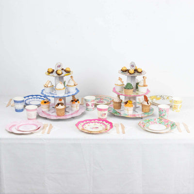 Colorful dessert stand with cupcakes and paper cups on a table setting.