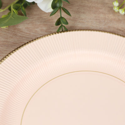 Pink decorative plate with gold rim on a wooden surface.
