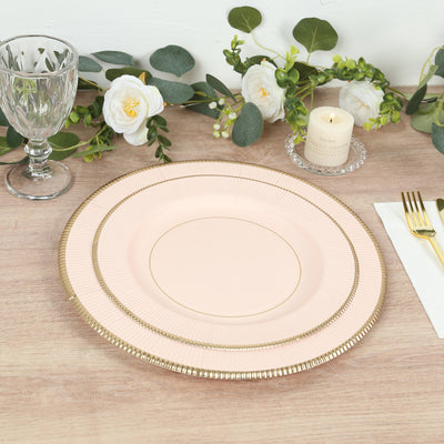 Pink decorative plate with gold trim on a wooden table setting.