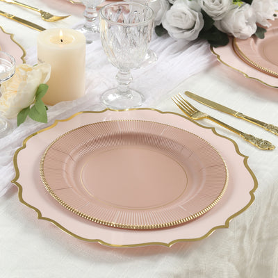 Elegant pink scalloped dinner plate with gold accents on a beautifully arranged table setting.