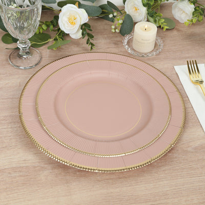 Elegant pink dinner plates with gold accents on a wooden table setting.