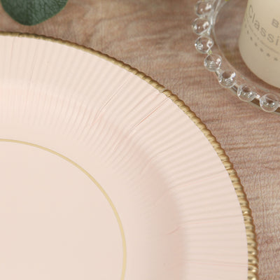 Pink decorative plate with gold rim details on a textured background.