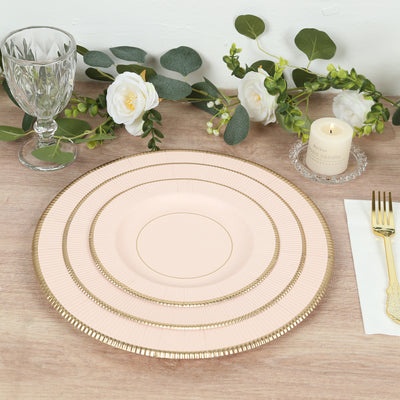 Elegant pink dinner plate with gold rim, styled with floral decor and glassware.