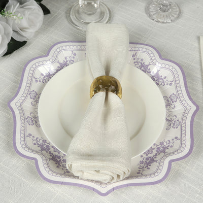 Elegant table setting with a white plate, purple rim, and textured napkin holder.