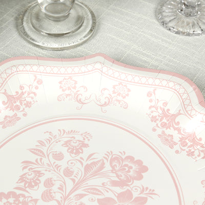 Decorative pink floral paper plate on a textured table surface.