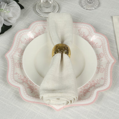 Elegant table setting with a pink floral plate, napkin, and golden napkin ring.