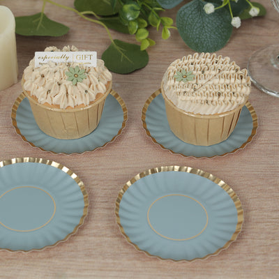 Decorative cupcakes on blue plates with gold edges, set against a soft background.