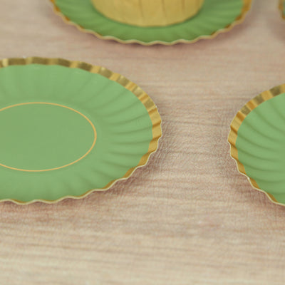 Green plates with gold rims arranged on a wooden surface.