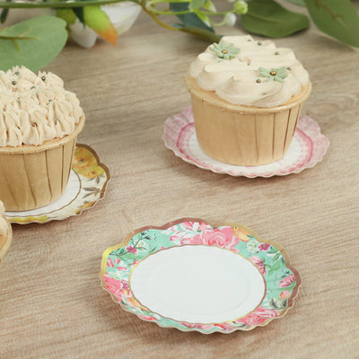 Decorative cupcake stand with floral design and cupcakes on a wooden table.