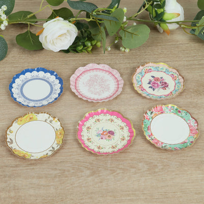 Set of six decorative plates in various floral designs on a wooden surface.