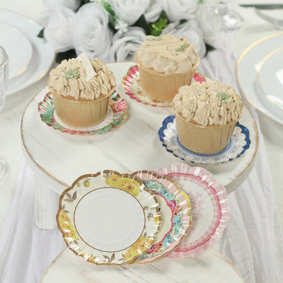 Cupcakes with decorative frosting on elegant paper plates, styled for a celebration.