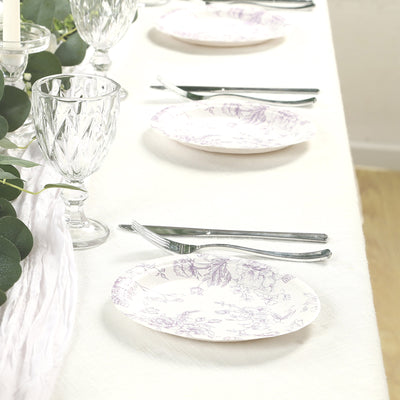 Elegant floral dinner plates set on a dining table with glassware and utensils.