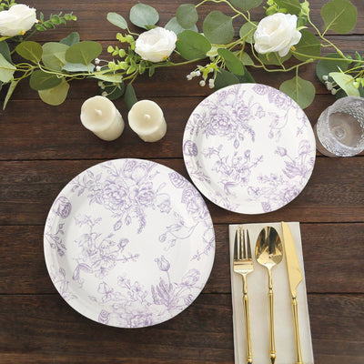 Elegant floral dinner plates with gold cutlery and candles on a rustic wooden table.