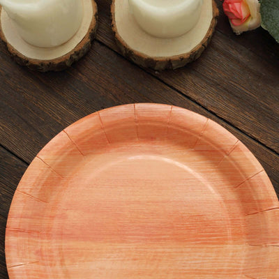 Orange disposable paper plate on a wooden table with candles.