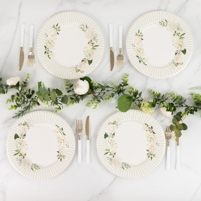 Elegant floral dinner plates arranged with greenery on a marble surface.