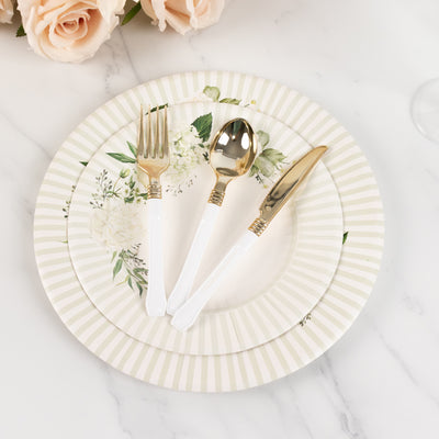 Elegant floral dinnerware set with gold-accented cutlery on a marble surface.