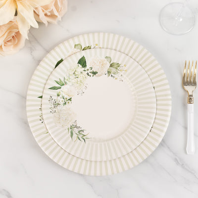 Floral design plate with a striped border on a marble surface.