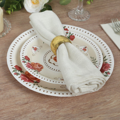 Elegant floral dinnerware set with napkin and gold napkin ring on a wooden table.
