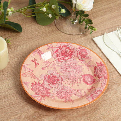 Floral patterned dinner plate in peach and pink tones on a wooden table.